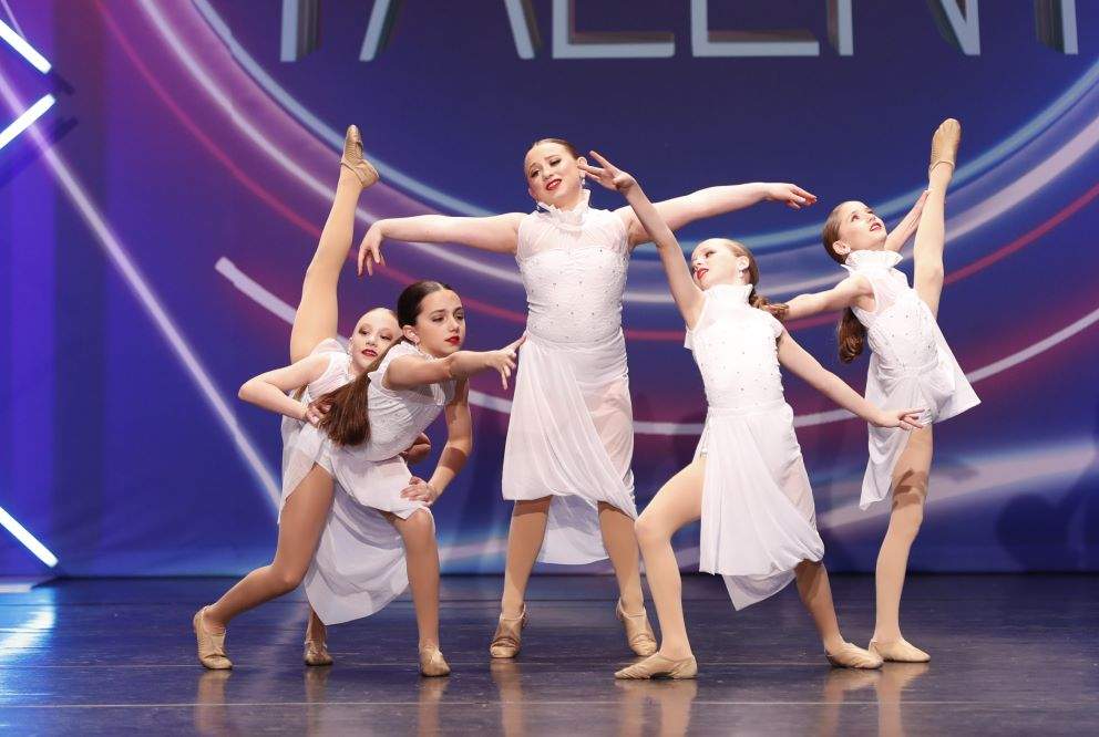 A group of dancers wearing white outfits